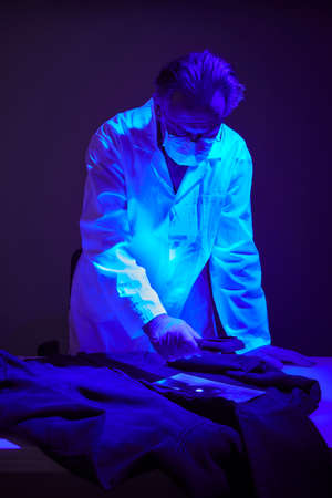 Checking of suspected person dress by forensic specialist in crime labの写真素材