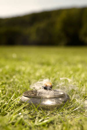 Detail of metal burner smoking in park for meditating ritual