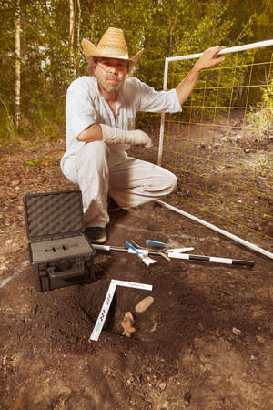 Archeologist on tropical location during find of rare votive woman statue
