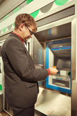 Man stalked when withdrawing cash from ATM machineの写真素材