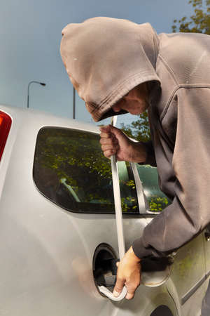Addicted man in black hooded shirt stealing car