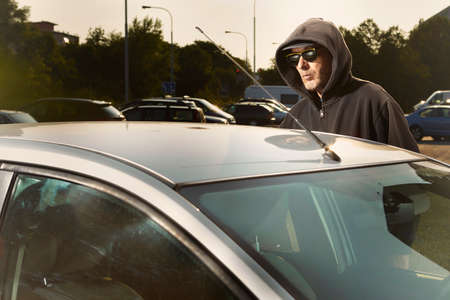Addicted man in black hooded shirt stealing carの写真素材