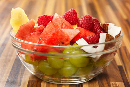 Fruit healthy salad made of grapes, watermelon, raspberry, pineapple and coconutの写真素材