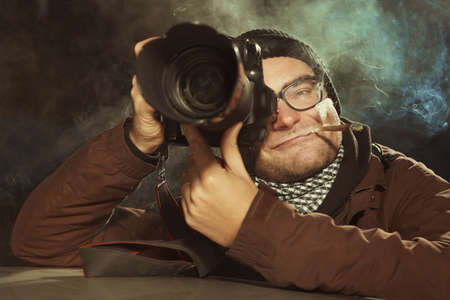 Photographer smoking cigarette waiting in the evening time for person to catch