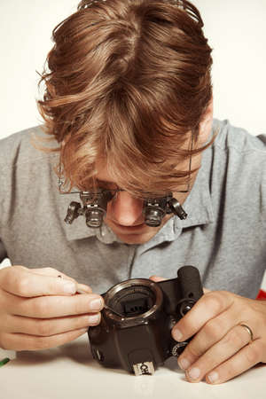 Crazy technician repairing digital camerabody bad way like a doctorの写真素材