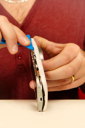 Man working on repairing of broken smartphone with zoom lensの写真素材