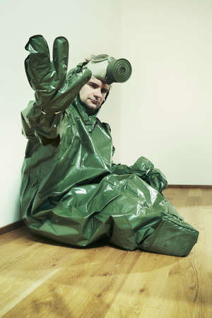 Ugly man in empty apartment dressed to protective suit and maskの写真素材