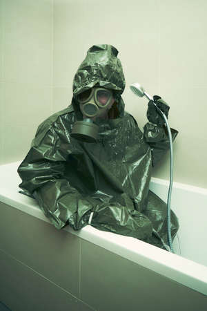 Ugly man in bathroom dressed to protective suit and mask showering