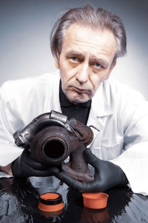 Man checking and measuring carbonized turbocharger on table