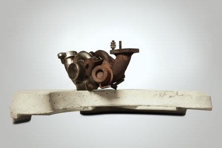 Rusty and carbonized old turbocharger on concrete weight from washing machineの写真素材