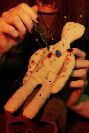 Voodoo witch spelling fetish doll practicing magic ritual