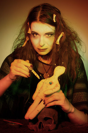 Voodoo witch spelling fetish doll practicing magic ritual