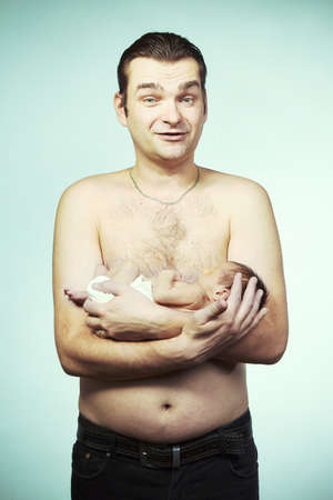 Father holding his newborn baby boy on his chestの写真素材