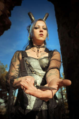 Mysterious woman sorcerer ready to fight in ruins by sword and spellの写真素材