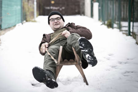 Adult man enjoying winter with classic retro wooden water slideの写真素材