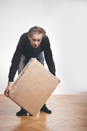 Man unpacking paper box with set of three laminated wood drawers
