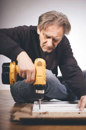 Man unpacking and assembling set of three drawersの写真素材