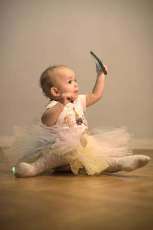 Pretty little girl posing on wooden floor for portraitの写真素材