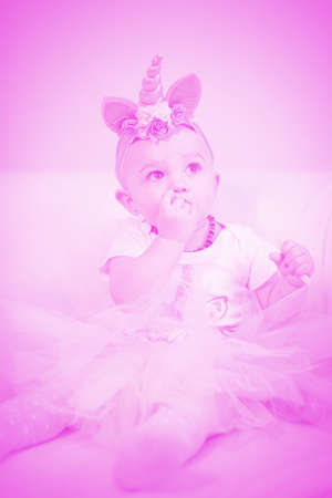 Pretty little girl posing on wooden floor for portraitの写真素材