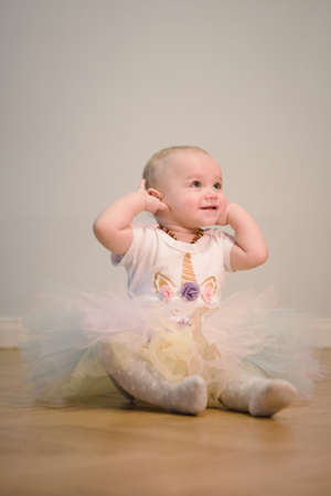 Pretty little girl posing on wooden floor for portraitの写真素材