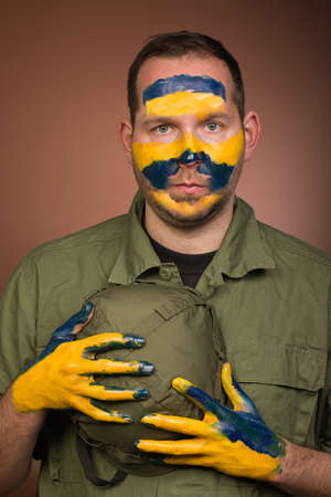 Man expressing respect to Ukraine with national colors on face