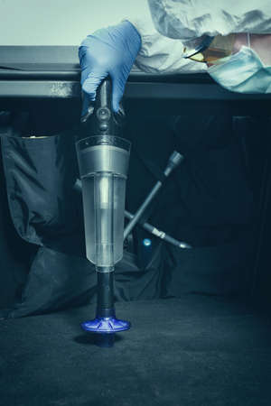 Criminologist technician collecting evidence with vacuum and micro filter