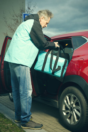 Delivery man with fresh food in bag moving to next contract