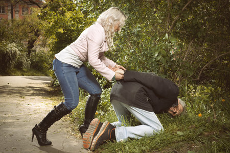 Secret police agent capturing deviant attacker in city parkの写真素材