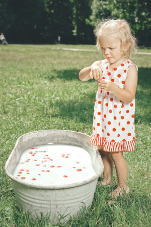 Little girl enjoying bath in retro metal sheet bath tub in parkの写真素材