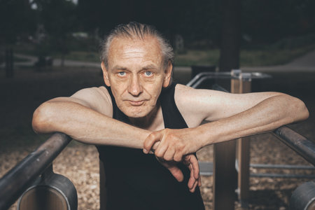 Ugly man of bad condition trying workout in outdoor gymの写真素材