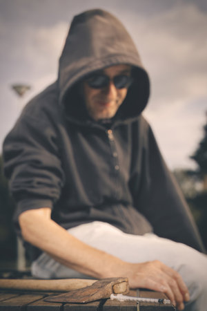 Aggressive older man under the influence of drugs in sunny city parkの写真素材