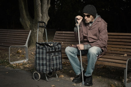 Senior citizen walking with wheel cart in city parkの写真素材