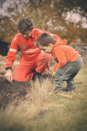 Little boy with his father playing as a craftsman and gardener in autumnの写真素材