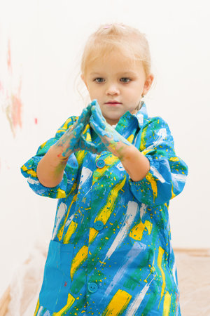 Little blonde girl handpainting clear white house wallの写真素材
