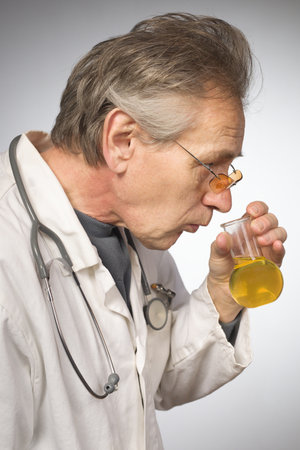 Doctor practitioner in traditional retro medical gown determining disease from urineの写真素材