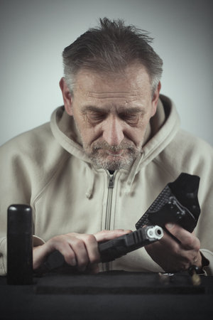 Man takes care of semi automatic pistol handgun at home