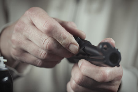 Man takes care of semi automatic pistol handgun at homeの写真素材