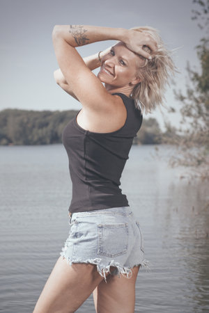 Pretty lady in summer lake posing for portrait in daytimeの写真素材