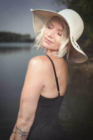 Pretty lady in summer lake posing for portrait in daytimeの写真素材