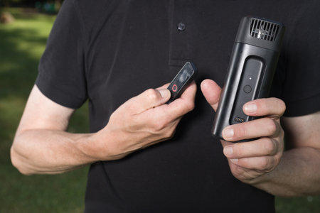 Older man uses two types of smoke machine generators on outdoor locationの写真素材
