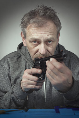 Man takes care of six inch revolver caliber .357 magnum at homeの写真素材