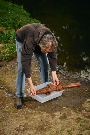 Senior citizen fishing with magnet in city lakeの写真素材