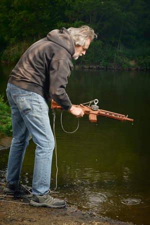 Senior citizen fishing with magnet in city lakeの写真素材