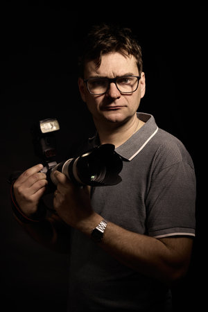 Photographer man in glasses and shirt with camera isolatedの写真素材