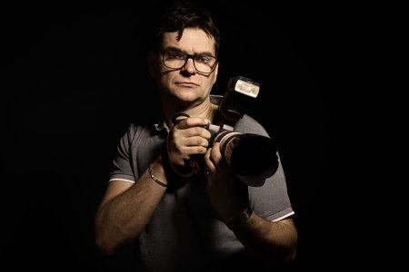 Photographer man in glasses and shirt with camera isolatedの写真素材