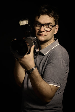 Photographer man in glasses and shirt with camera isolatedの写真素材