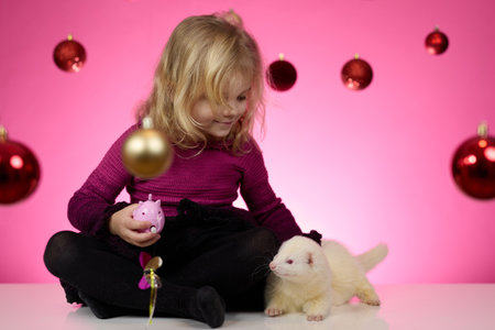 Nice little girl posing in studio for christmas portrait on pink backgroundの写真素材