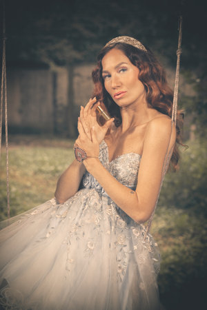 Pretty woman in nice apparel posing on countryside locationの写真素材