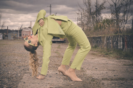 Pretty lady in green costume posing on industrial locationの写真素材