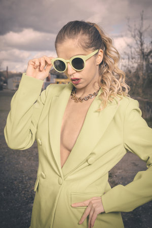 Pretty lady in green costume posing on industrial locationの写真素材